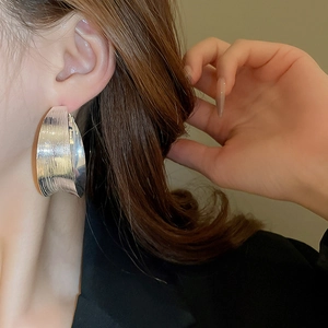 Detail of silver textured hoop earring with horizontal brushed matte finish on model