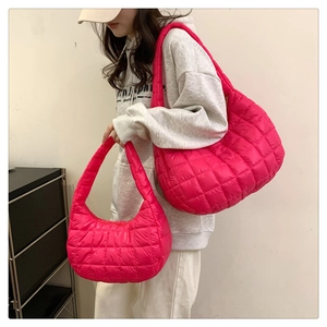 Close-up of vibrant pink quilted puffer shoulder bags with glossy nylon finish