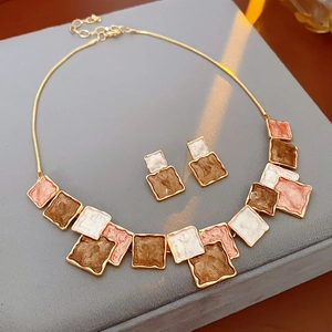 Macro detail of geometric oil-drop pendant necklace set with chic square enamel accents