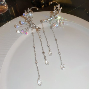 Detailed close-up of a silver butterfly ear cuff with sparkling crystals and long tassels