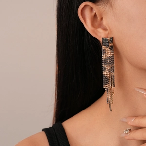 Close-up of leopard print rhinestone tassel earrings on a model with sparkling crystals