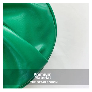 Detailed macro view of the bright green lychee grain leather texture on the handbag