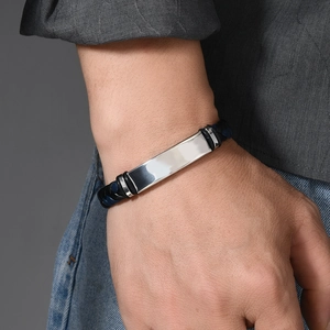 Close-up of men's silver steel plate and navy blue braided leather bracelet on wrist