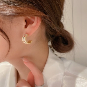 Detail view of French vintage enamel C-shaped earrings with red tulip floral pattern