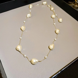 Macro detail of Baroque pearls and gold-plated chain links on an elegant necklace