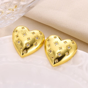 Close-up of golden heart earrings featuring sparkling starburst cubic zirconia inlay