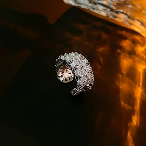 Vue macro d'une bague argentée ouverte avec oxydes de zirconium marquises et ronds