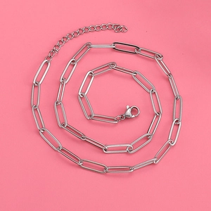 Minimalist silver stainless steel paperclip chain necklace on a soft pink background