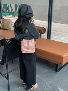 Nahaufnahme der rosa Leder-Beuteltasche mit goldener Kette an einem Kindermodell