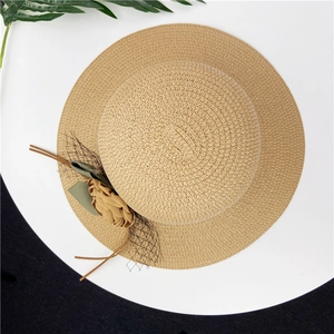 Detail of khaki straw sun hat with floral accents, green ribbon and black mesh veil