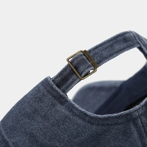 Dettaglio di un cappello baseball in denim lavato con fibbia in bronzo stile vintage