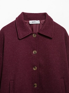 Detailed view of burgundy wool blend jacket collar and four brown closure buttons