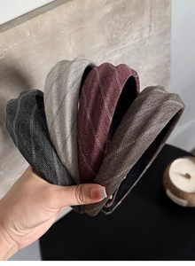 Detail of four padded herringbone fabric headbands in grey, burgundy, and brown tones