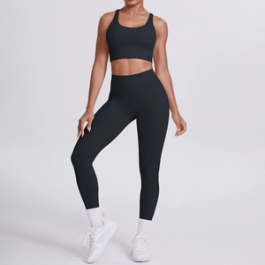 Dettaglio del reggiseno sportivo con spalline incrociate e leggings yoga neri in tessuto opaco