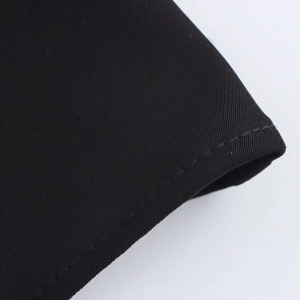 Detailed close-up of high-quality black twill fabric with precise stitching details