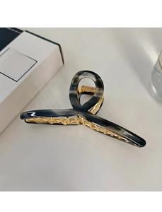 Detailed view of a marble pattern hair claw clip with golden metal spring and teeth