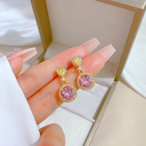 Detail of pink crystal earrings in gold setting with micro-pave heart shaped ear hooks
