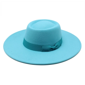 Détail du chapeau en laine bleu sarcelle avec ruban assorti et large bord plat