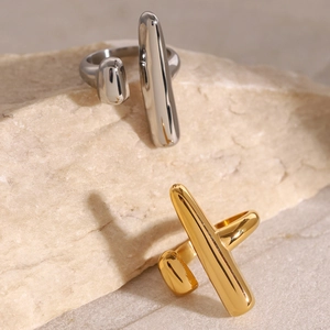 Minimalist geometric 18k gold and silver stainless steel open rings on a stone surface