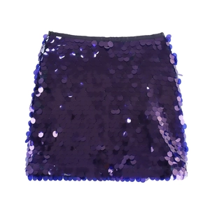 Gros plan détaillé sur les grandes paillettes rondes violettes d'une mini-jupe de fête