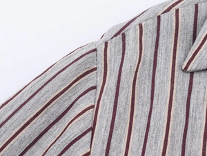 Detailed close-up of grey and red striped fabric showing the shoulder stitching and texture