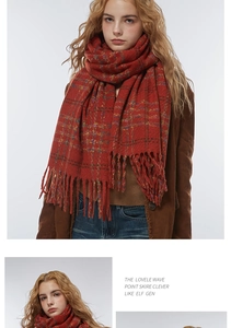 Close-up of red plaid scarf showing thick wool texture and long fringed tassels