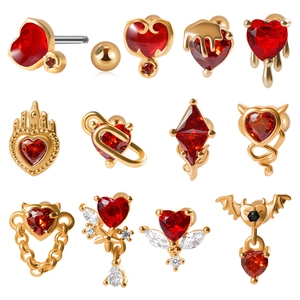 Makroaufnahme verschiedener roter Herzohrringe mit Goldfinish und Gothic Teufelskette Details