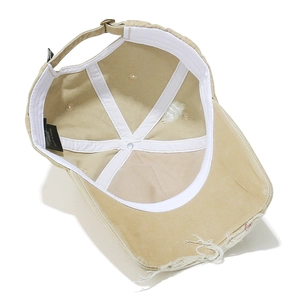 Detailed interior of khaki vintage baseball cap showing stitching and distressed brim edge