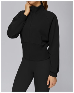 Detail einer schwarzen Damen-Sportjacke mit Stehkragen und breitem Rippenbund am Saum