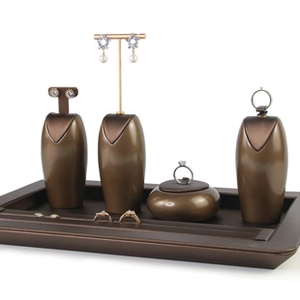 Detailed arrangement of bronze jewelry display stands and rectangle trays on white