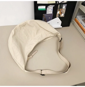 Détail du sac bandoulière en nylon beige avec sangle réglable et boucle de fermeture