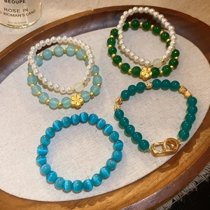 Detalle de pulseras de cuentas de piedra natural y perlas con elegantes toques dorados