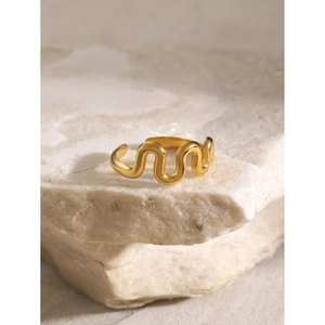Makroaufnahme der 18k Goldwellen-Ring mit flüssigem Design auf Naturstein