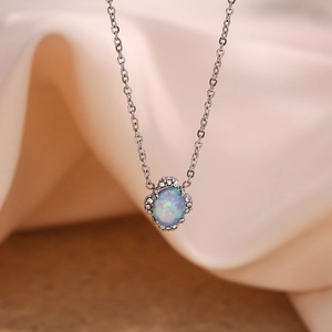 Détail du pendentif en opale bleue ovale avec bordure en cristal sur chaîne argent