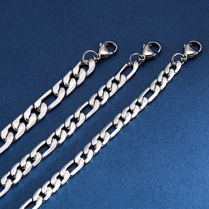 Detailed close-up of three silver Figaro chain bracelets with sturdy lobster clasps