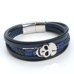 Close-up of blue braided leather bracelet featuring a silver skull and magnetic clasp
