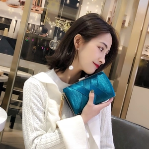 Elegant peacock blue satin clutch bag with pleated texture and gold fringe tassels