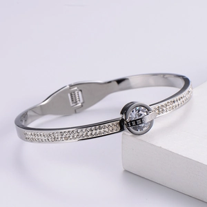 Close-up of silver-tone crystal-encrusted spring bracelet with Roman numeral details