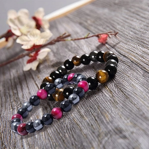 8mm Natural tiger eye and hematite beaded bracelets on a rustic grey wood background