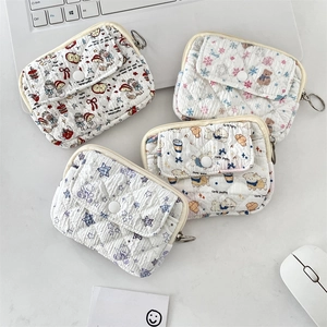 Detail of four quilted cotton coin purses with cartoon prints and button flap pockets