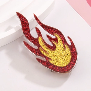 Acrylic glitter flame brooch in red and yellow hues displayed on a white stand
