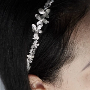 Adjustable silver flower headband with metallic petal design for a minimalist fashion look