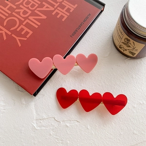 Three-heart acrylic hair clips in matte pink and jelly red with golden duckbill grip