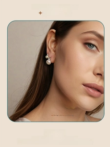 Detailed close-up of an elegant pearl and moissanite stud earring worn by a model