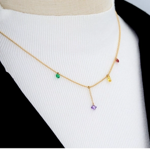 Detail of gold bead necklace with colorful gemstone pendants and Y-shape drop design