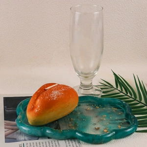 Detail of dark green resin cloud tray with gold foil flakes and a realistic bread model