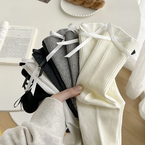 Detail of ribbed socks in various colors with delicate bow accents on the cuffs