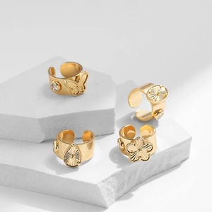 Macro detail of 18K gold plated butterfly and teardrop rings with zircon inlay