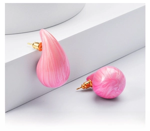 Detail of pink marble texture on teardrop and round stud earrings with gold posts