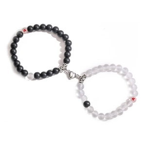 Detail of magnetic heart clasp connecting black and frosted white couple bracelets